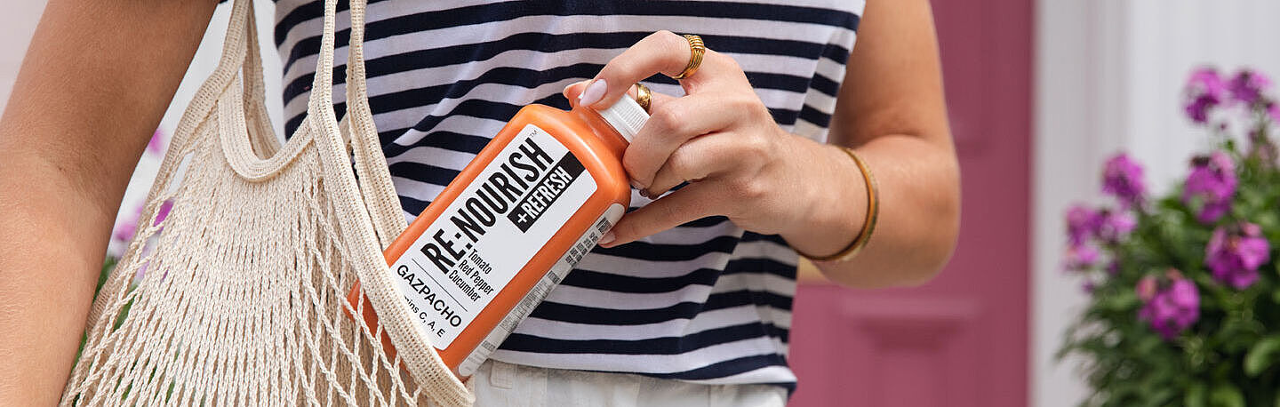 Woman's hand takes a bottle from a shopping bag